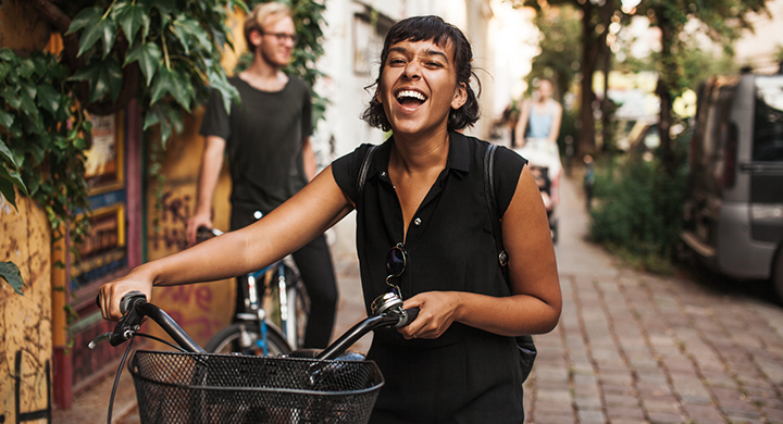 Girl Smiling on a Bike Outside