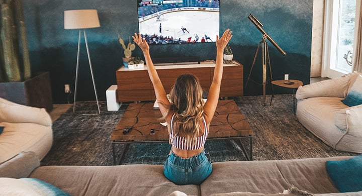 Woman Cheering on a Sports Team while Watching a Televised Game - Toggle Renters Insurance Cost