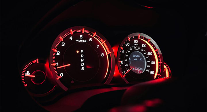 The dashboard of a car with red lights