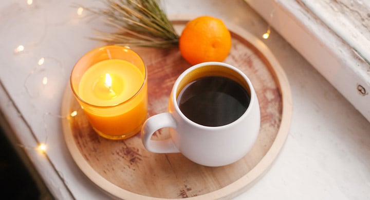 Tray with coffee cup and yellow candle