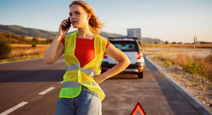 Woman on the phone in a traffic control vest