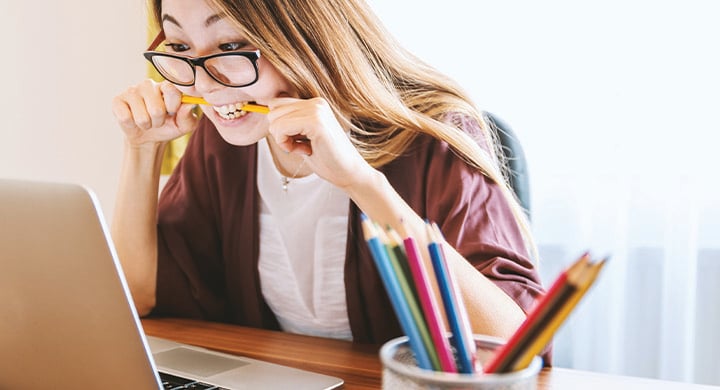 Woman Chewing on Pencil