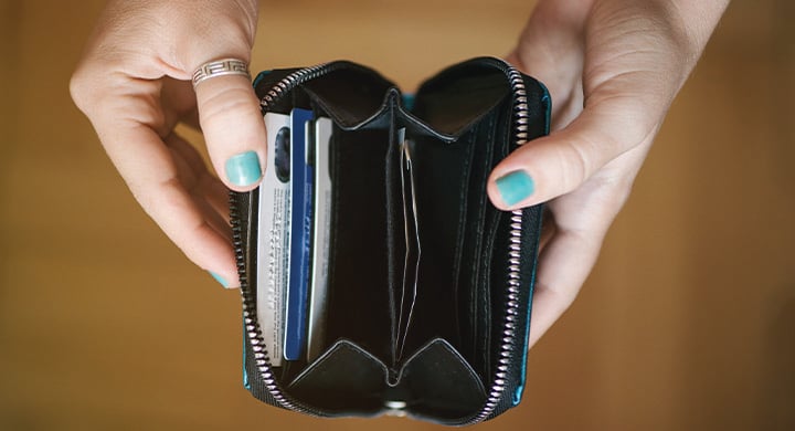 Woman's hands holding an open wallet.